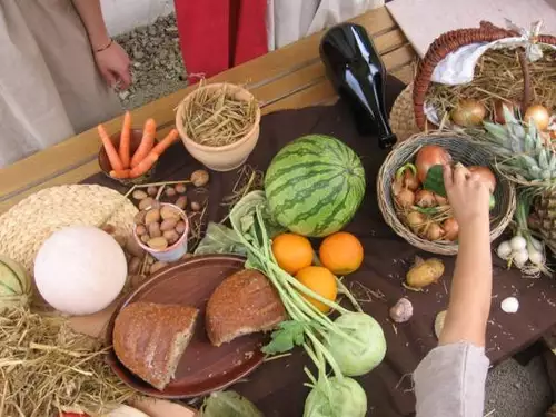 Ein Marktstand entsteht: Mit Brot, Melonen, Feigen und sonstigen Produkten wird der Marktstand verziert.